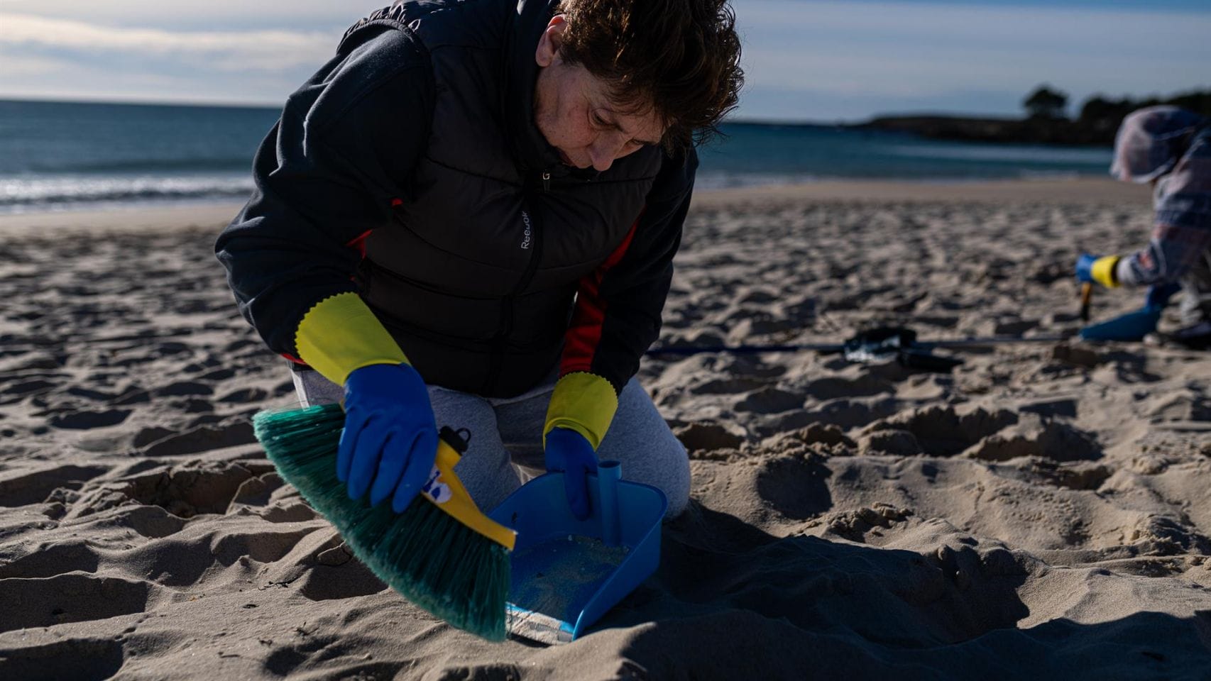 Voluntarios hacen una recogida de pellets en una playa gallega.