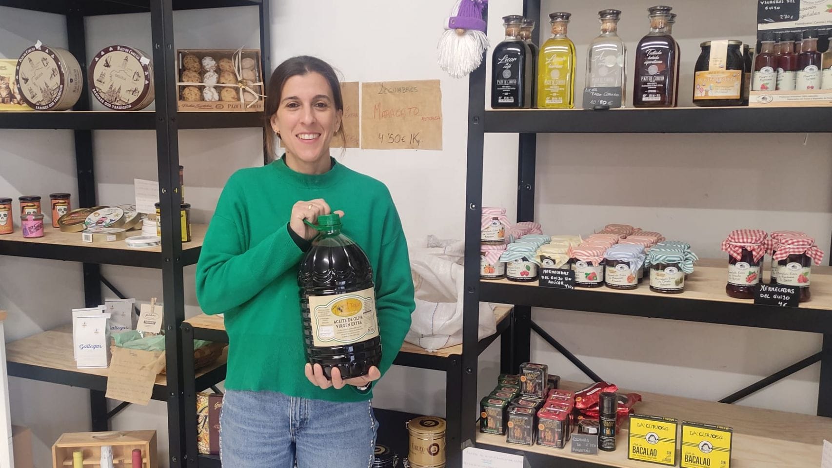 Jesica Muñoz en su tienda con una garrafa de aceite de la Almazara El Tejar