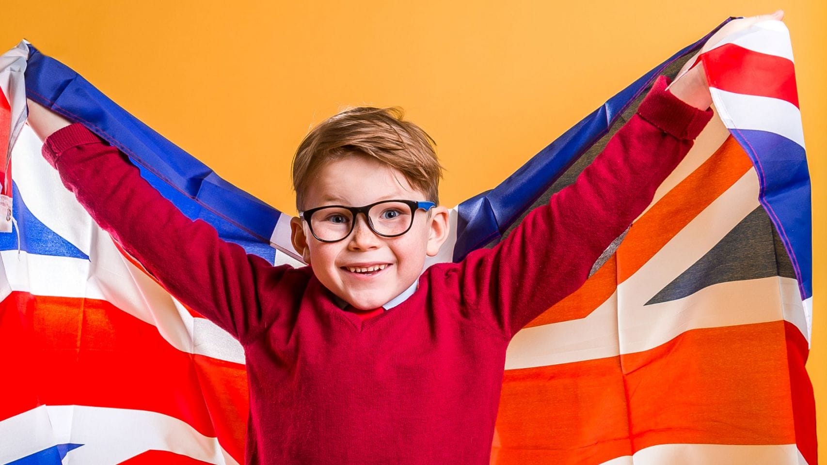Niño pequeño jugando con la bandera de Reino Unido.