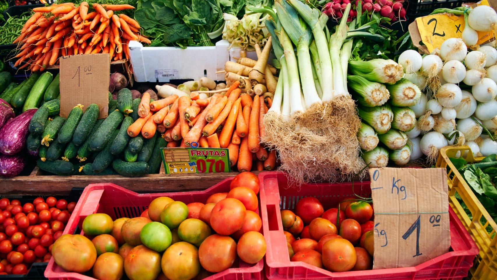 Puesto de verduras en un mercado al aire libre.